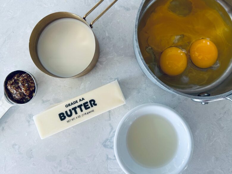 Overhead shot of ingredients to make Hollandaise sauce to pour over eggs benedict casserole before serving.