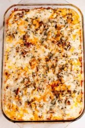 A freshly baked casserole with melted cheese on top in a glass baking dish.