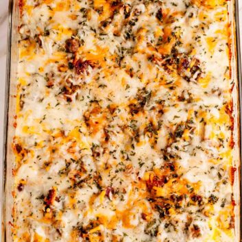 A freshly baked casserole with melted cheese on top in a glass baking dish.