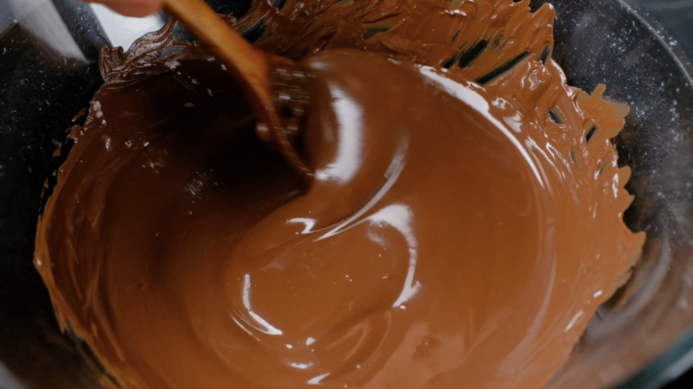 Chocolate coating for ice cream bon bons being stirred.