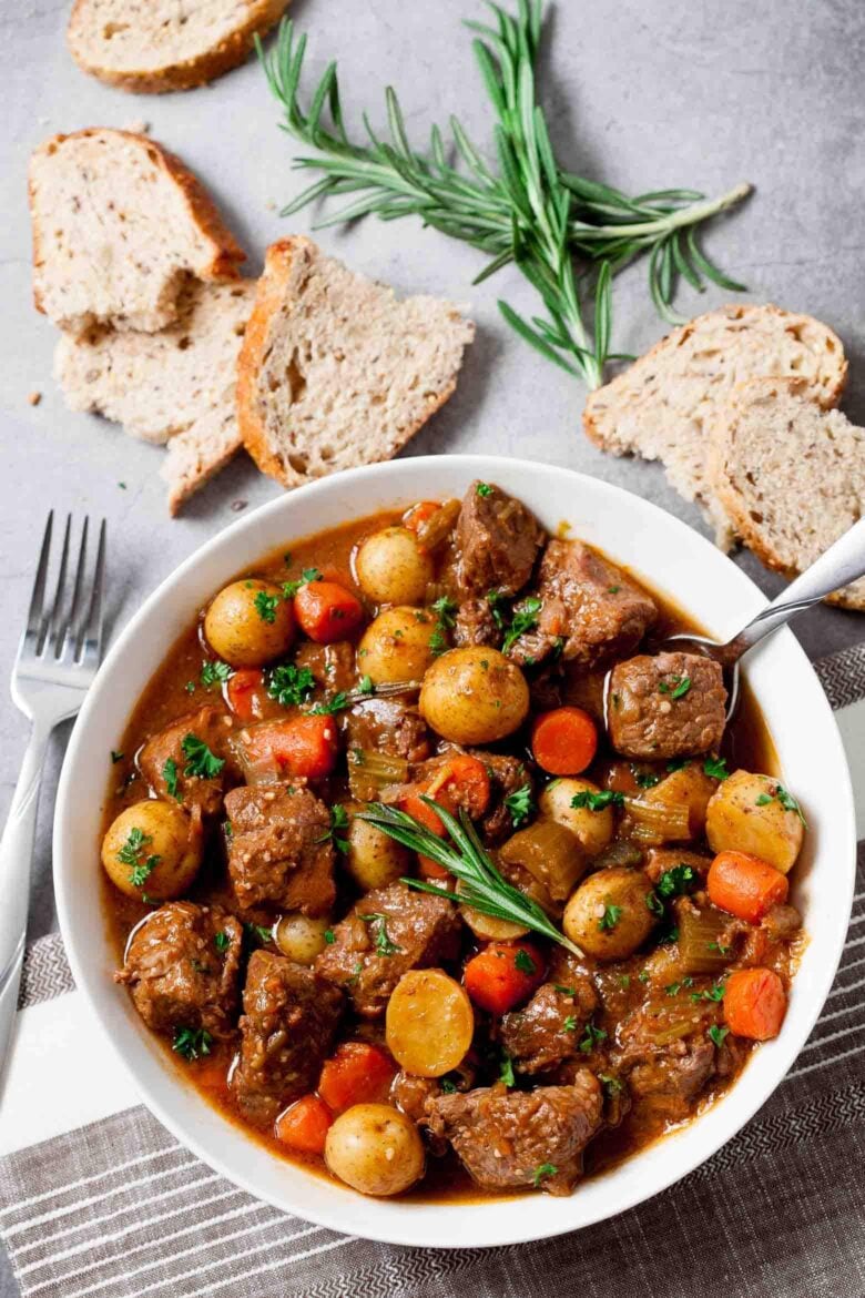 Irish Guinness Beef Stew in a bowl, with bread on the side. 