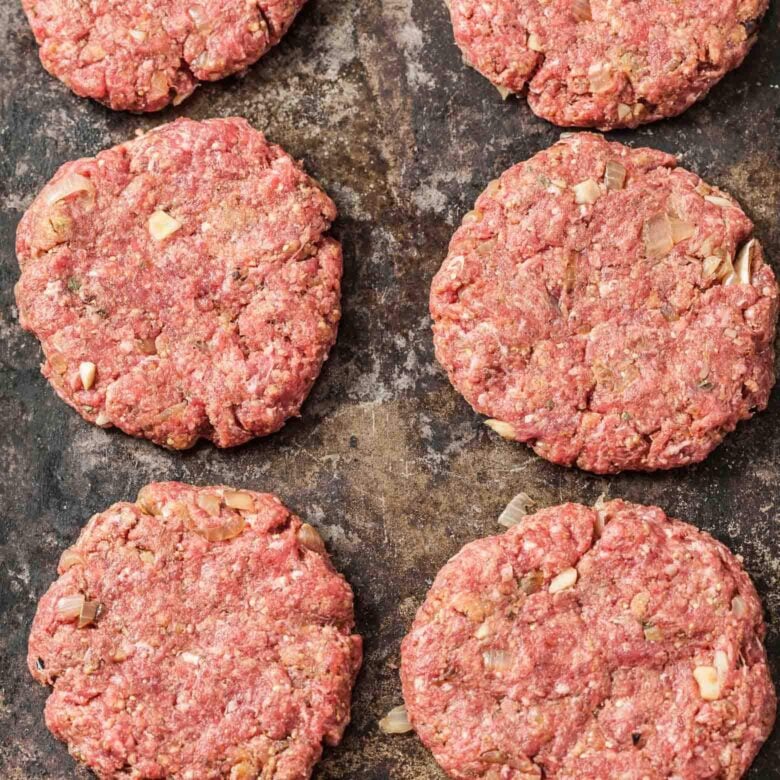 Closeup shot of salisbury steak patties being cooked in a pan.