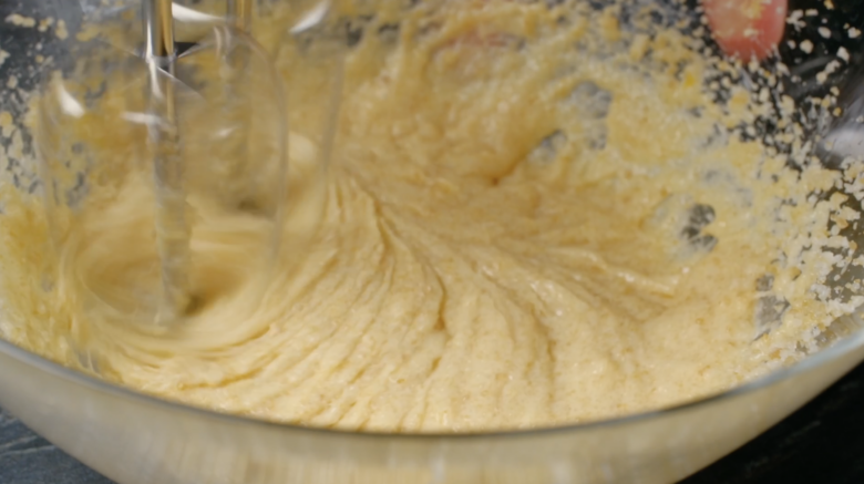 Butter being creamed with sugar in a mixing bowl.