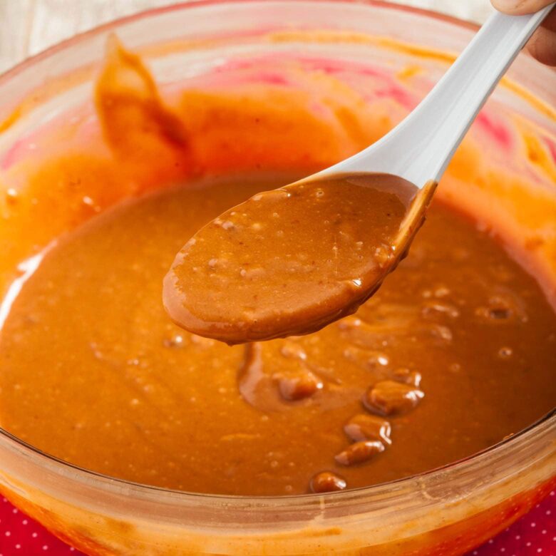 Closeup shot of a spoonful of Thai peanut sauce.