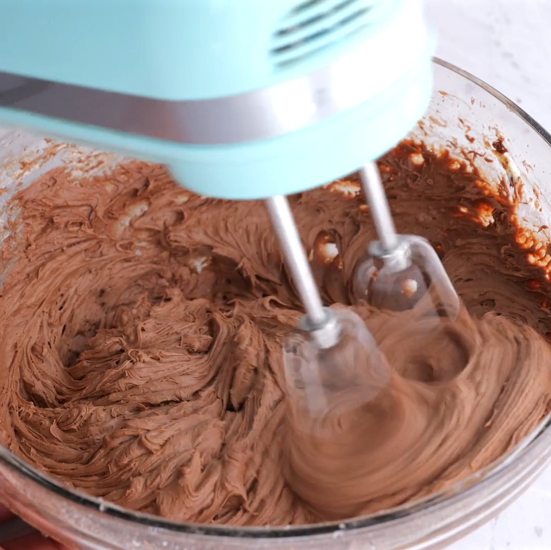 cream cheese frosting being beaten for easy chocolate sheet cake.
