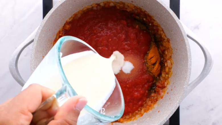 cream being added to chicken tikka masala sauce.