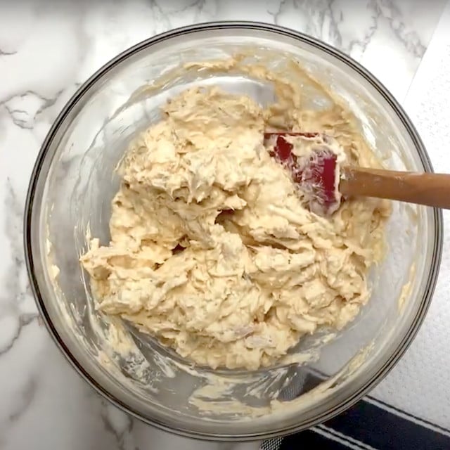 A mixing bowl with mixed ingredients to make Frank's buffalo chicken dip.
