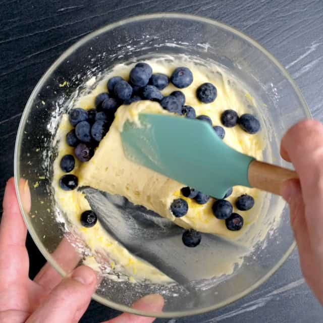 Fresh blueberries being folded into bread batter to make lemon blueberry bread.