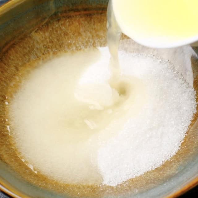 Lemon glaze ingredients being added in a mixing bowl.