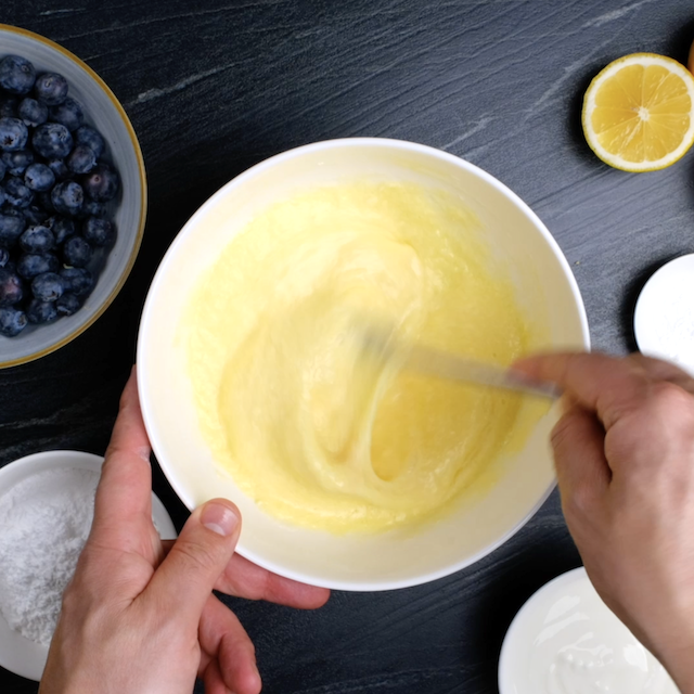 Egg mixture being beaten by a fork in a mixing bowl.