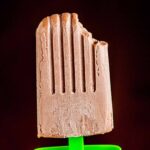 A fudge popsicle with a bite taken out of its top.