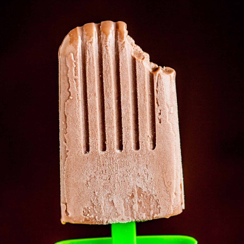 A fudge popsicle with a bite taken out of its top.
