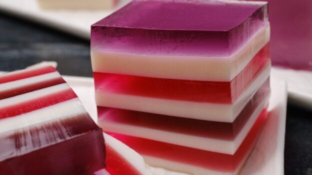 Closeup shot of sliced rainbow jello squares with clean lines.