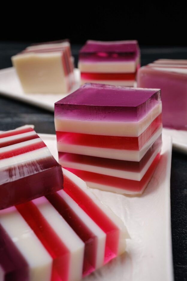 Closeup shot of sliced rainbow jello squares with clean lines.
