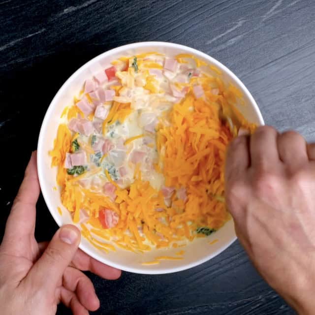 Quiche mixture being mixed in a large bowl.