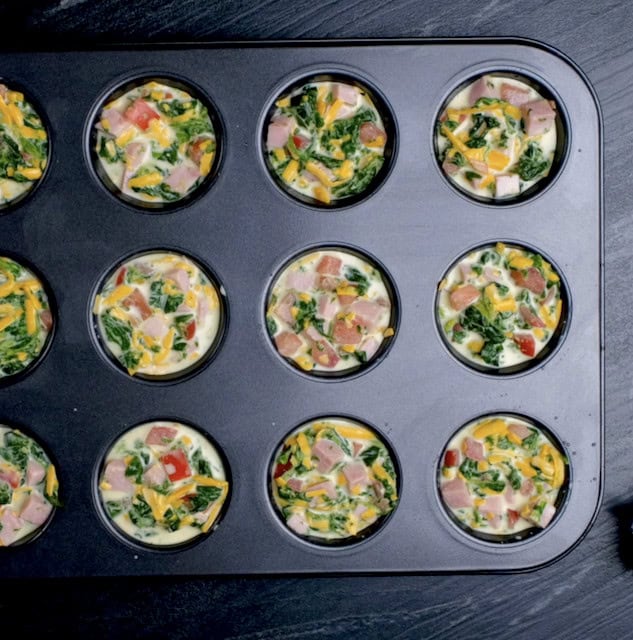 Quiche mixture in muffin pan, ready to be baked.