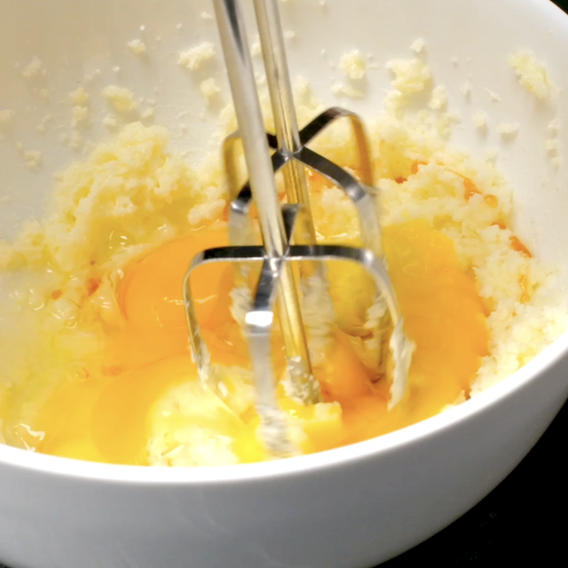 Eggs and vanilla being mixed into butter and sugar mixture.