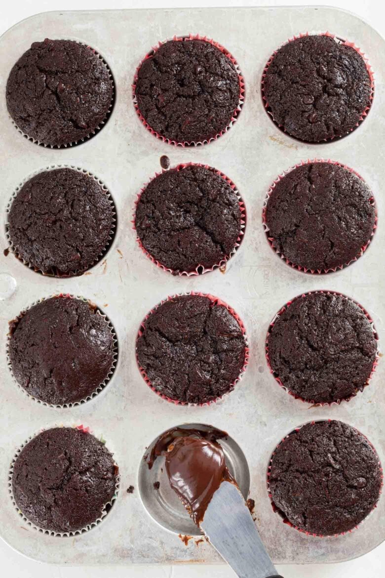 Overhead shot of a muffin tin with baked chocolate zucchini cupcakes.