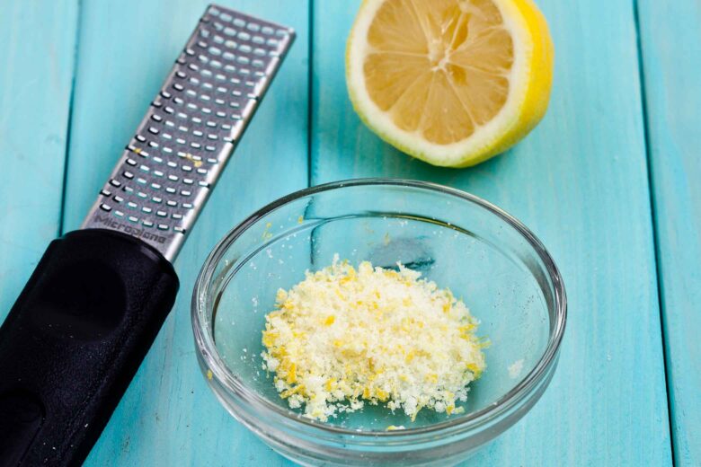 Ingredients to make lemon sugar topping for lemon icebox cake on a blue surface.