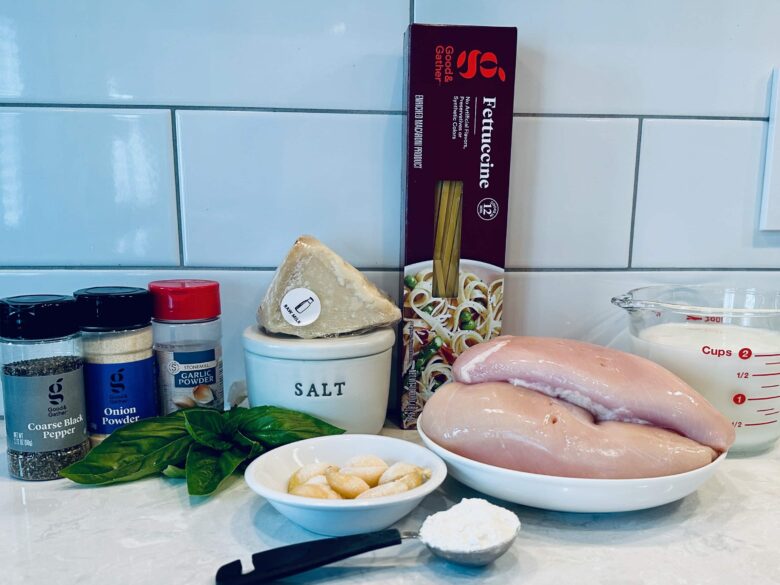 Ingredients to make healthy chicken Alfredo on a kitchen countertop.
