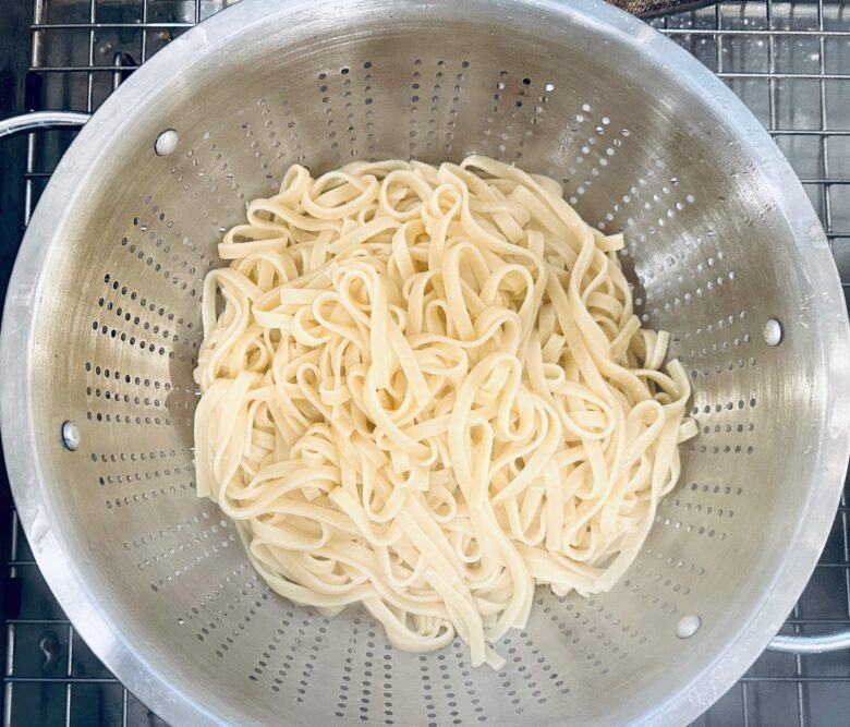 Fettuccini pasta drained to make healthy chicken Alfredo.