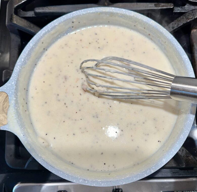 Mix and flour mixture being cooked on the stovetop to make healthy chicken Alfredo sauce.