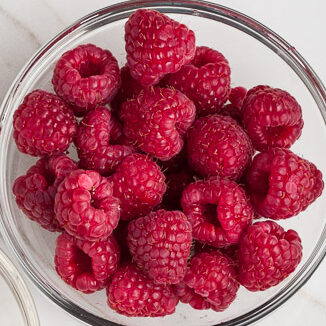 raspberries and white chocolate chips in bowls. 
