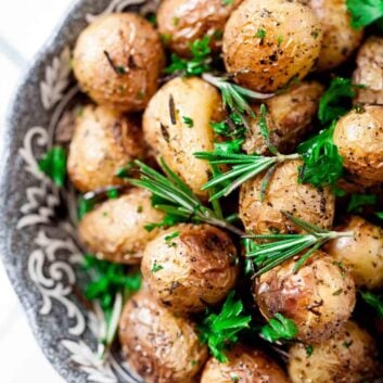 Overhead shot of garlic roasted baby potatoes garnished with freshly chopped parsley.
