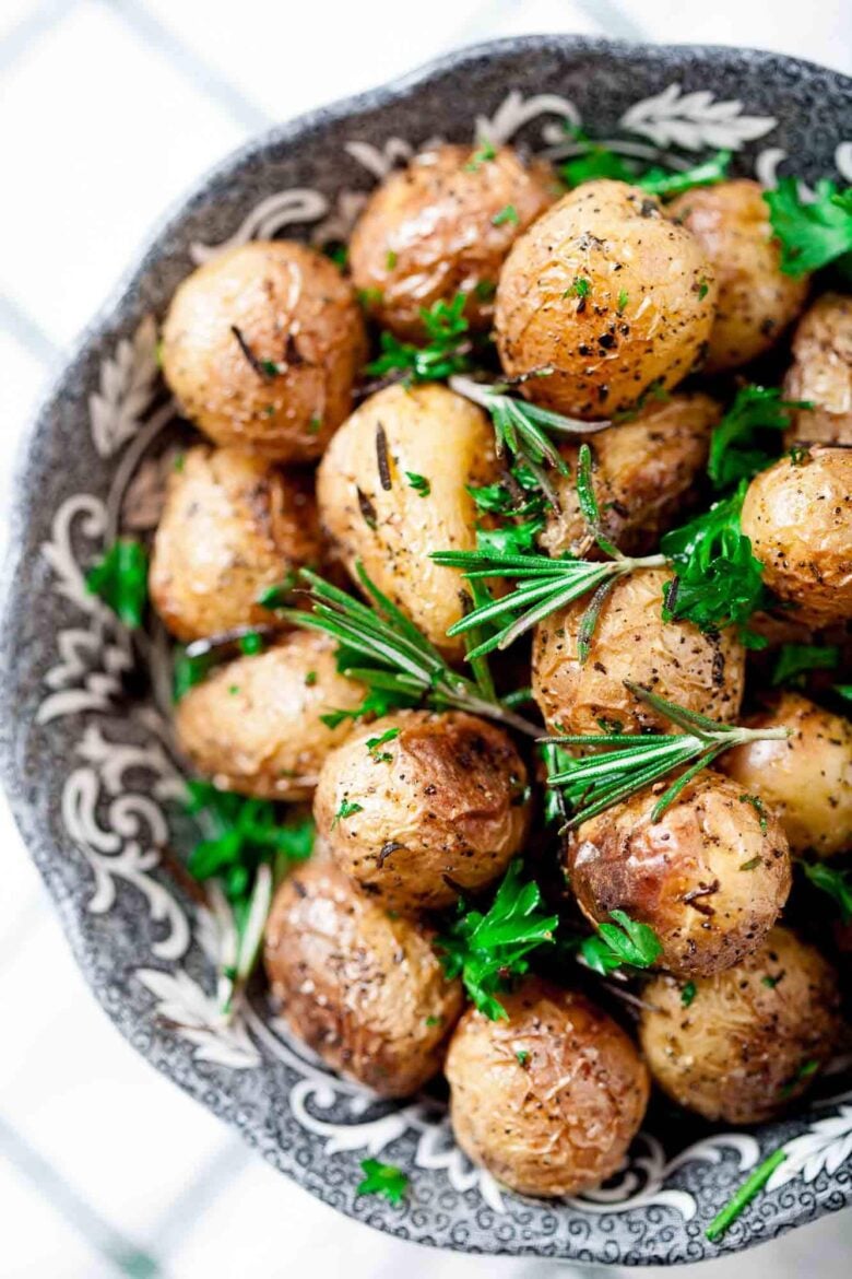 Overhead shot of garlic roasted baby potatoes garnished with freshly chopped parsley.