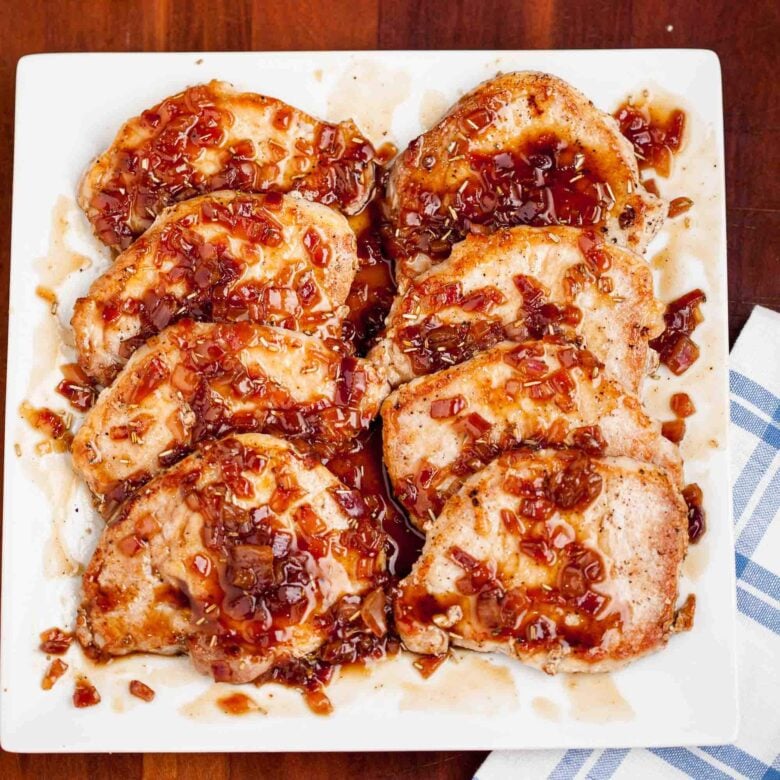 maple glazed pork chops garnished with sauce.