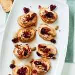 pumpkin crostini with goat cheese and bacon served on a platter.