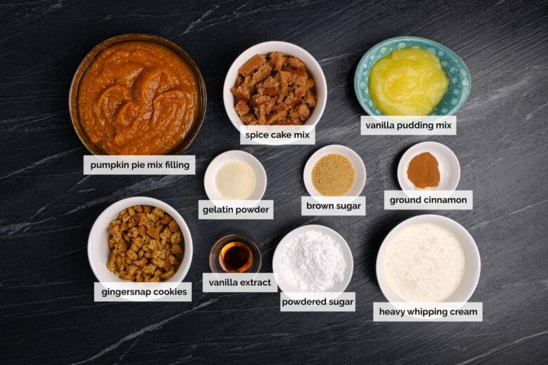 Overhead shot of ingredients to make Pumpkin Trifle on a dark surface.