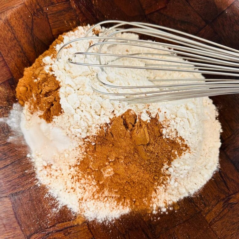 Dry ingredients to make pumpkin snickerdoodles being whisked in a bowl.