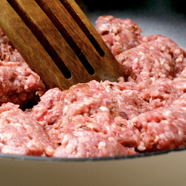 Sausage being crumbled and cooked in a large skillet you make cornbread sausage stuffing.