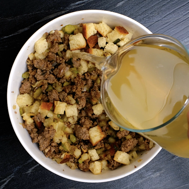 Broth being poured into cornbread mixture to make cornbread sausage stuffing.
