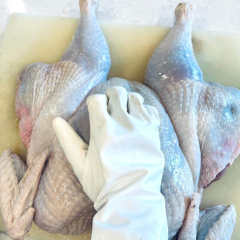 pressing breast bone of turkey to flatten.