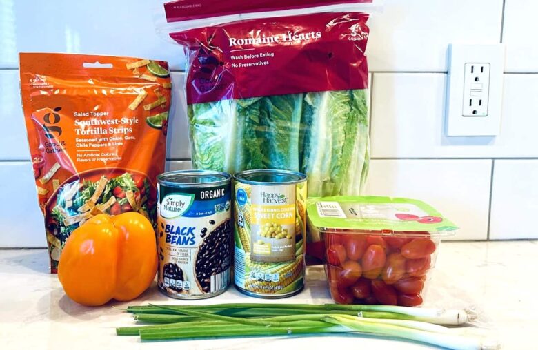 Ingredients to make Southwest chopped salad on a white kitchen counter.