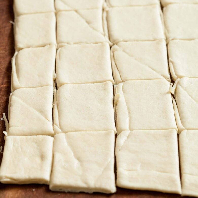 cranberry brie bites crescent dough cut into squares.