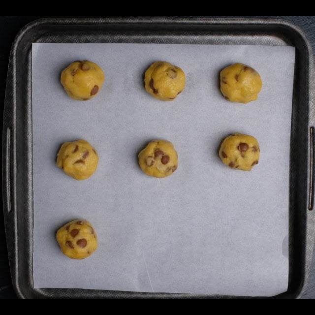 soft chocolate chip cookie dough balls on baking sheet.