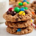 Three freshly baked monster cookies stacked on top of each other with colorful M&Ms on top.