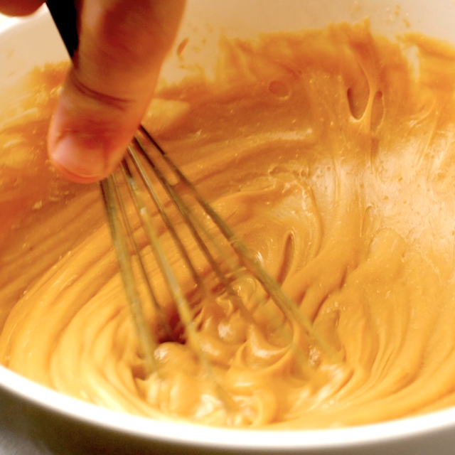 Monster cookies dough mixture being whisked in a mixing bowl.