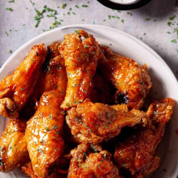 Overhead shot of Air Fryer Chicken Wings on a white plate with sauces on the side.