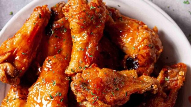 Overhead shot of Air Fryer Chicken Wings on a white plate with sauces on the side.