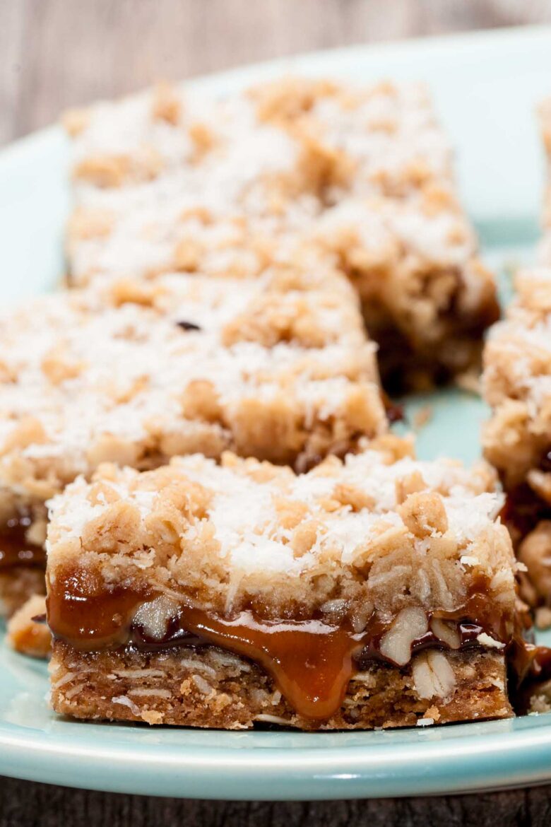 Closeup shot of caramelita bars with caramel oozing out and topped with finely shredded coconut.