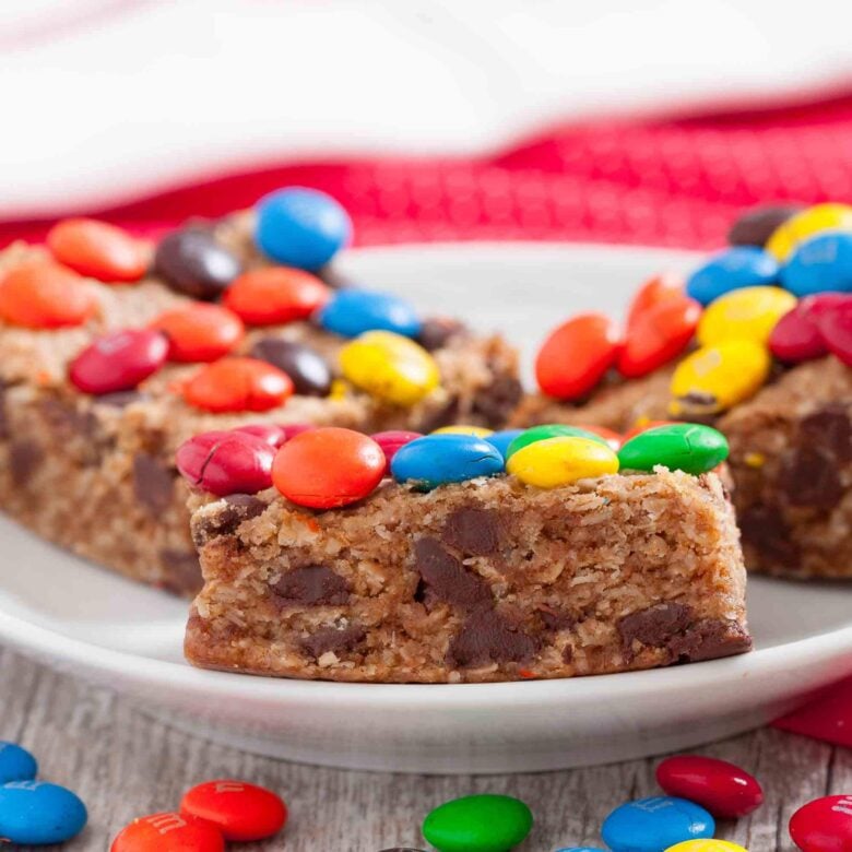 Close-up shot of colorful monster cookie bars with visible chocolate chips and M&Ms on top.
