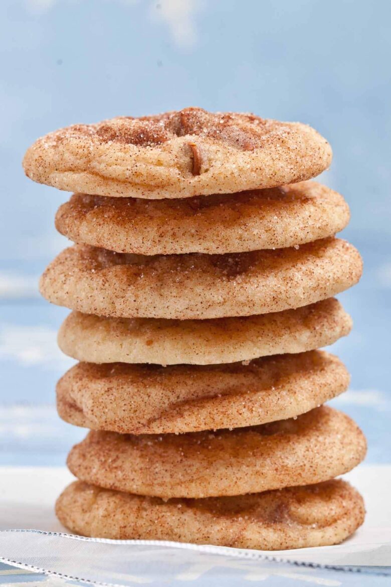 A closeup shot of a stack of chewy soft snickerdoodles with cinnamon-sugar coating.