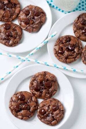 Dark Chocolate Chip Cookies on white plates, with blue polka dot straws on the side.