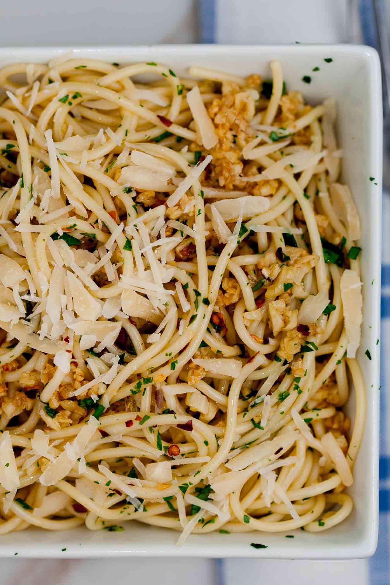 Overhead shot of lemon garlic pasta with minced parsley on top with visible red pepper flakes.