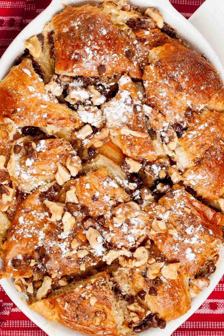 Overhead shot of a freshly baked Nutella bread pudding with chopped nuts.
