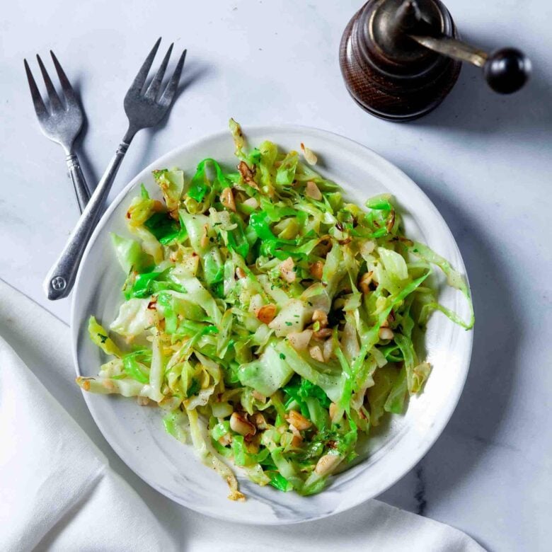 Overhead shot of a white bowl of freshly made sautéed cabbage.